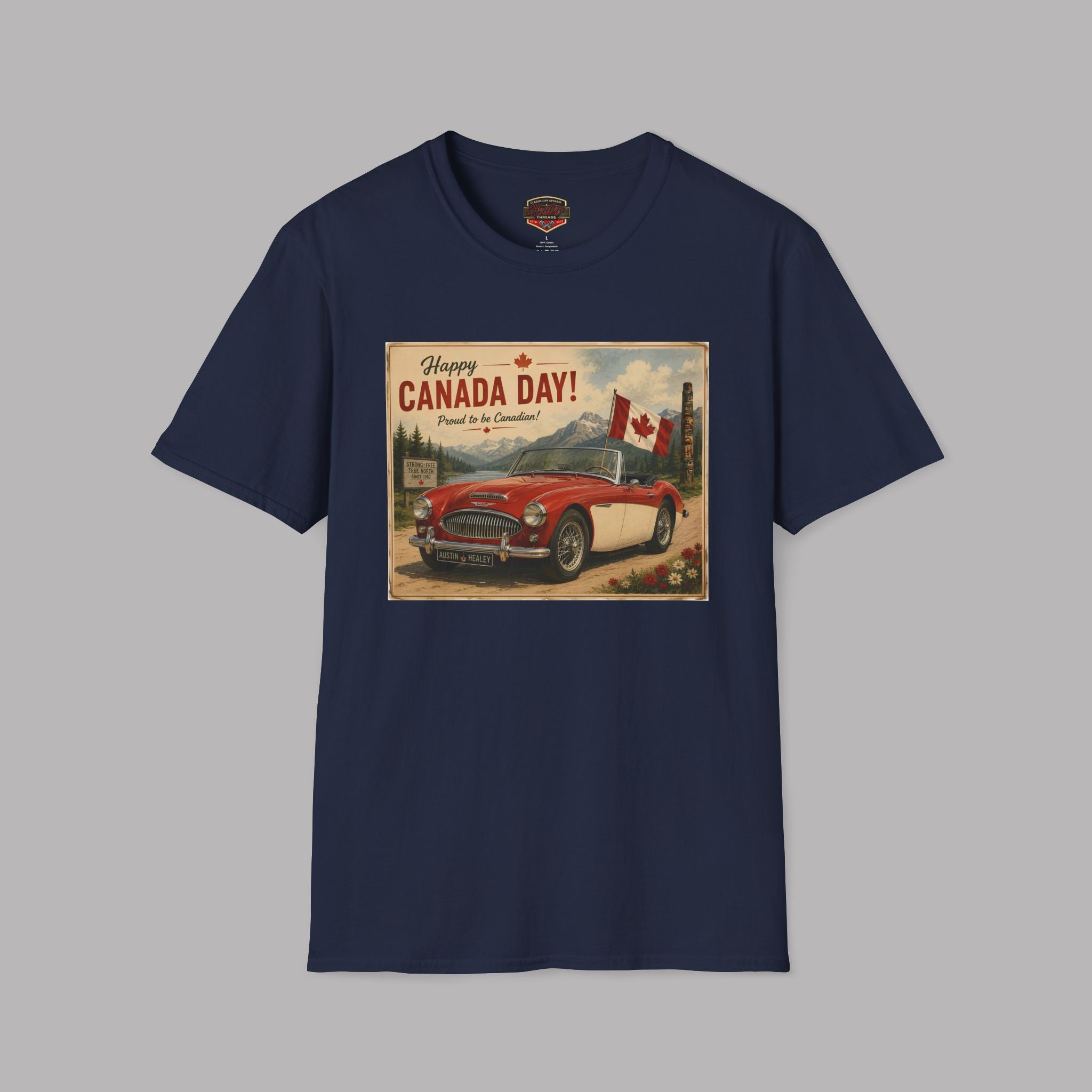 A navy blue short-sleeve crewneck t-shirt featuring a vintage-style 'Happy Canada Day!' graphic print on the front, showing a red car and Canadian flags, displayed against a solid gray background.