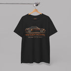 Black t-shirt with classic car graphic and text on a hanger against a gray background