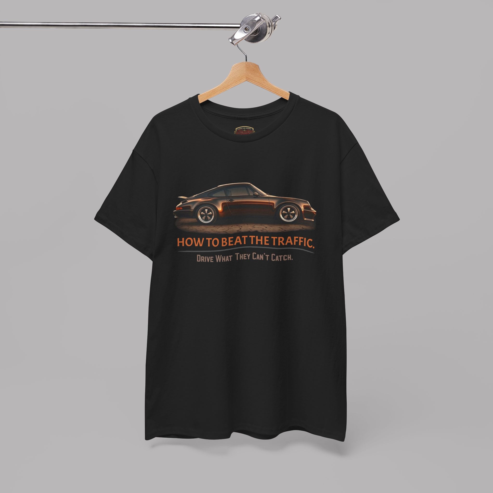 Black t-shirt with classic car graphic and text on a hanger against a gray background