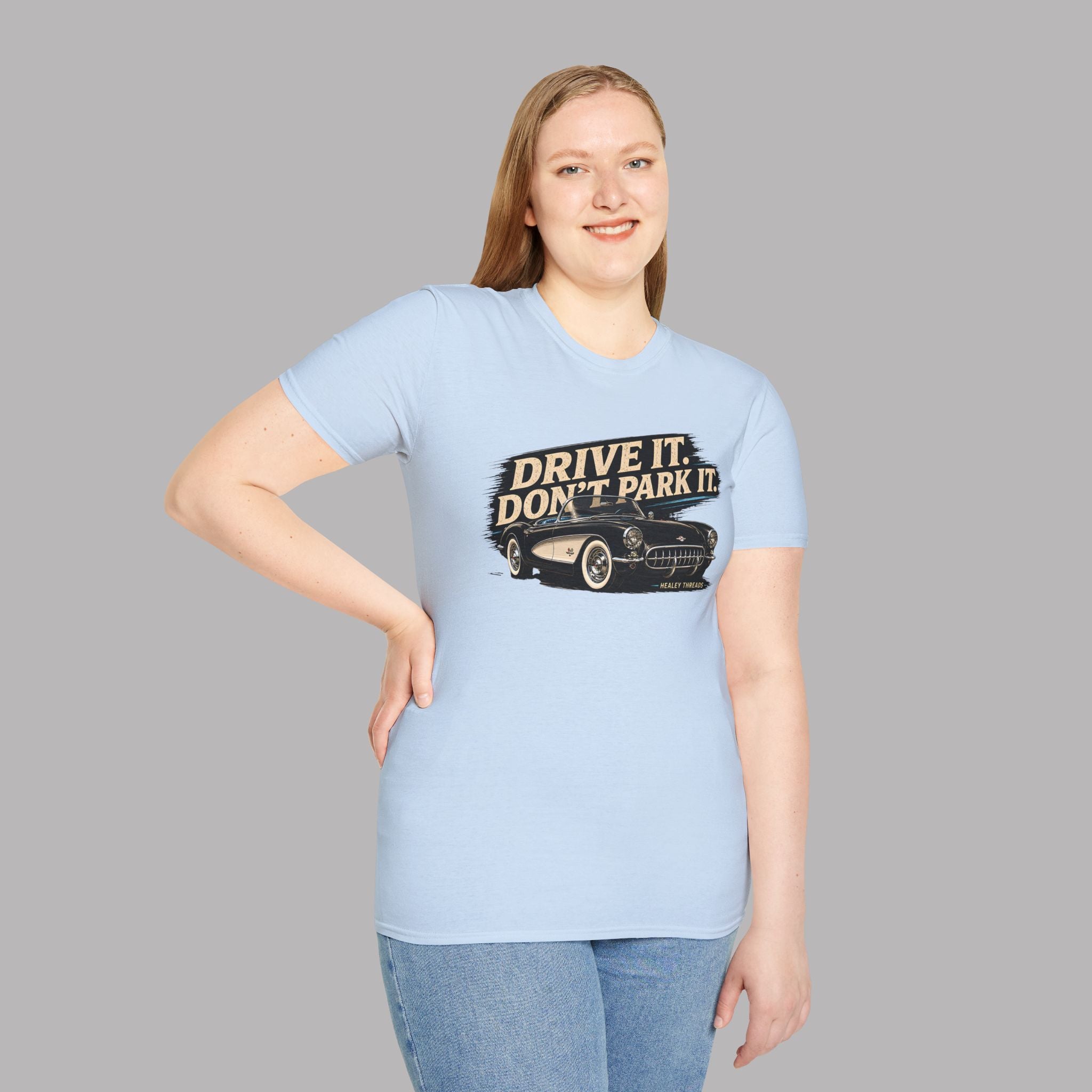 Woman wearing a light blue t-shirt with a vintage car graphic and text on a gray background