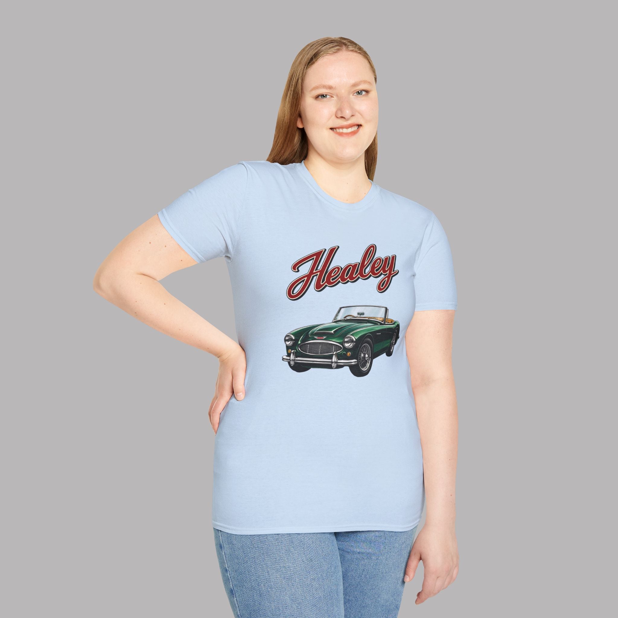Woman wearing a light blue t-shirt with a green classic car graphic and 'Healey' text on a gray background