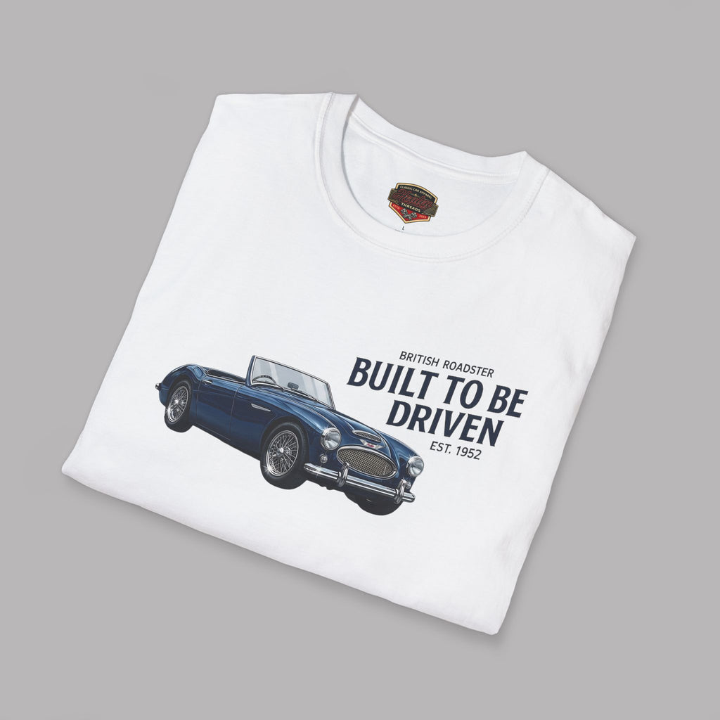Folded white t-shirt with a blue vintage car graphic and text on a gray background