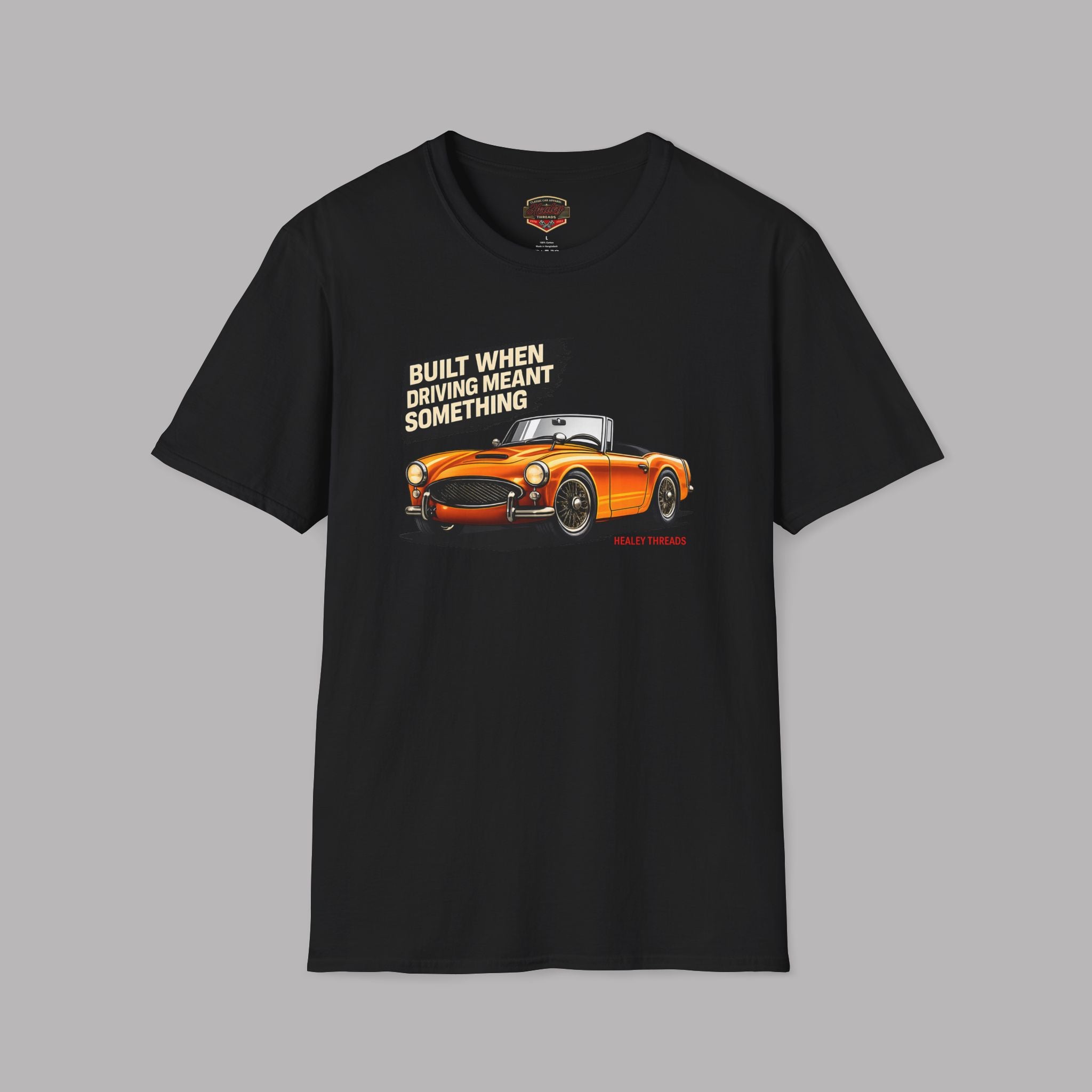 Black t-shirt with orange car graphic and text on a gray background