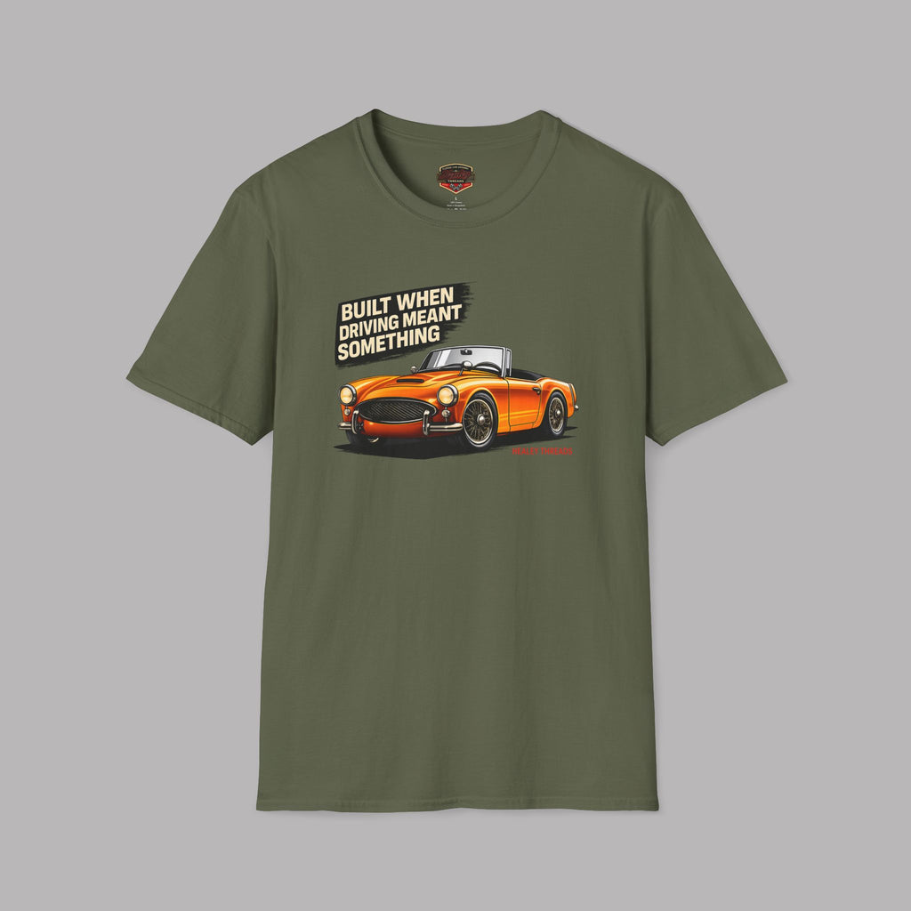 Military green t-shirt with orange car graphic and text on a gray background