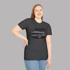 Woman wearing a dark heather t-shirt with a classic car graphic design on a gray background