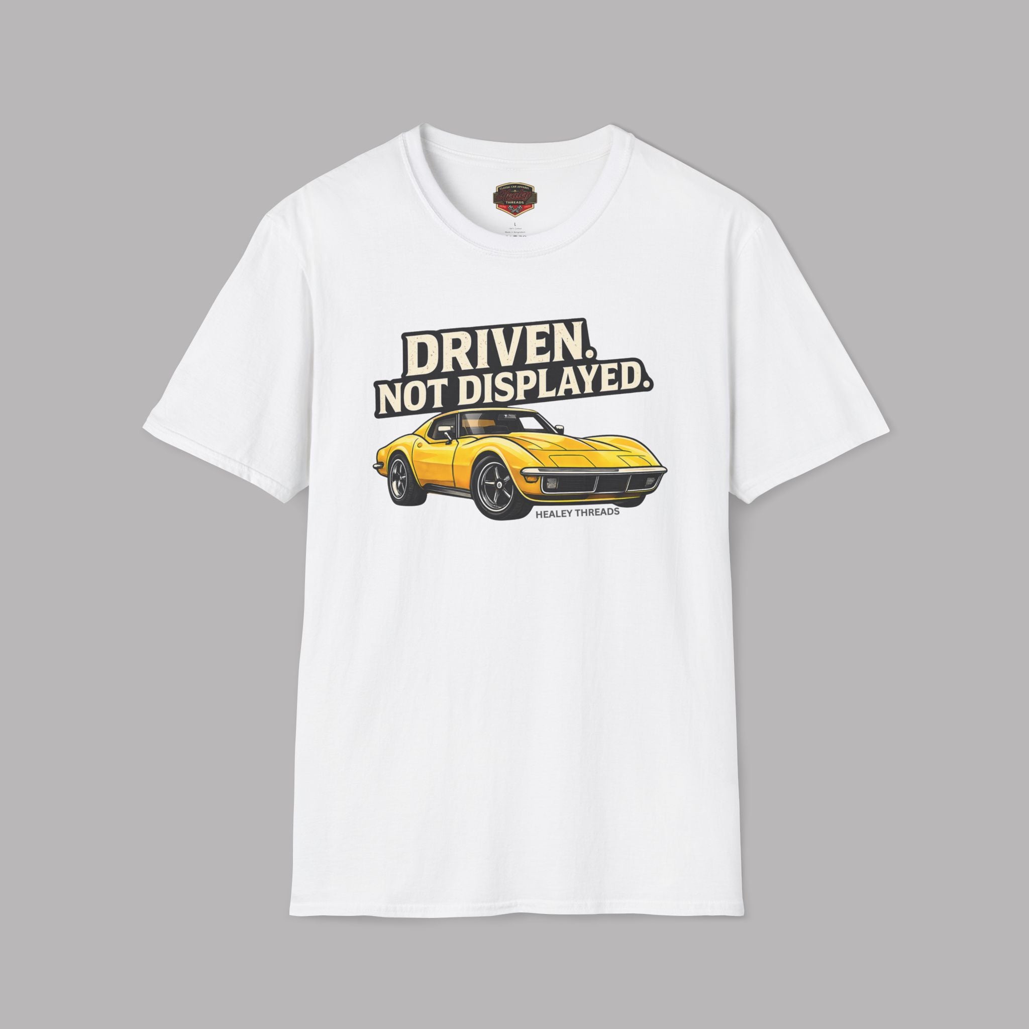 White t-shirt with a yellow muscle car graphic and text on a gray background