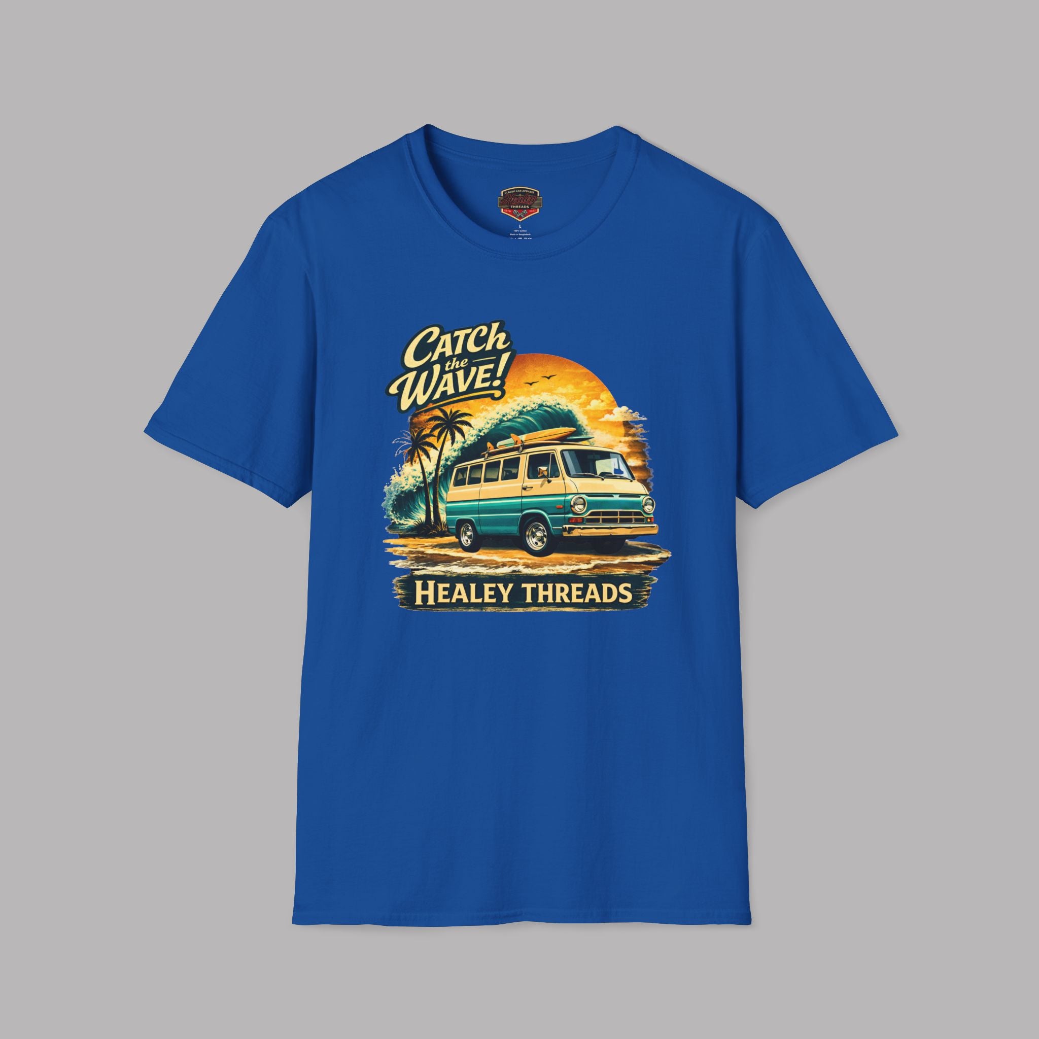 Royal blue t-shirt with a graphic design of a vintage van and text 'Catch Wave! Healey Threads' on a gray background