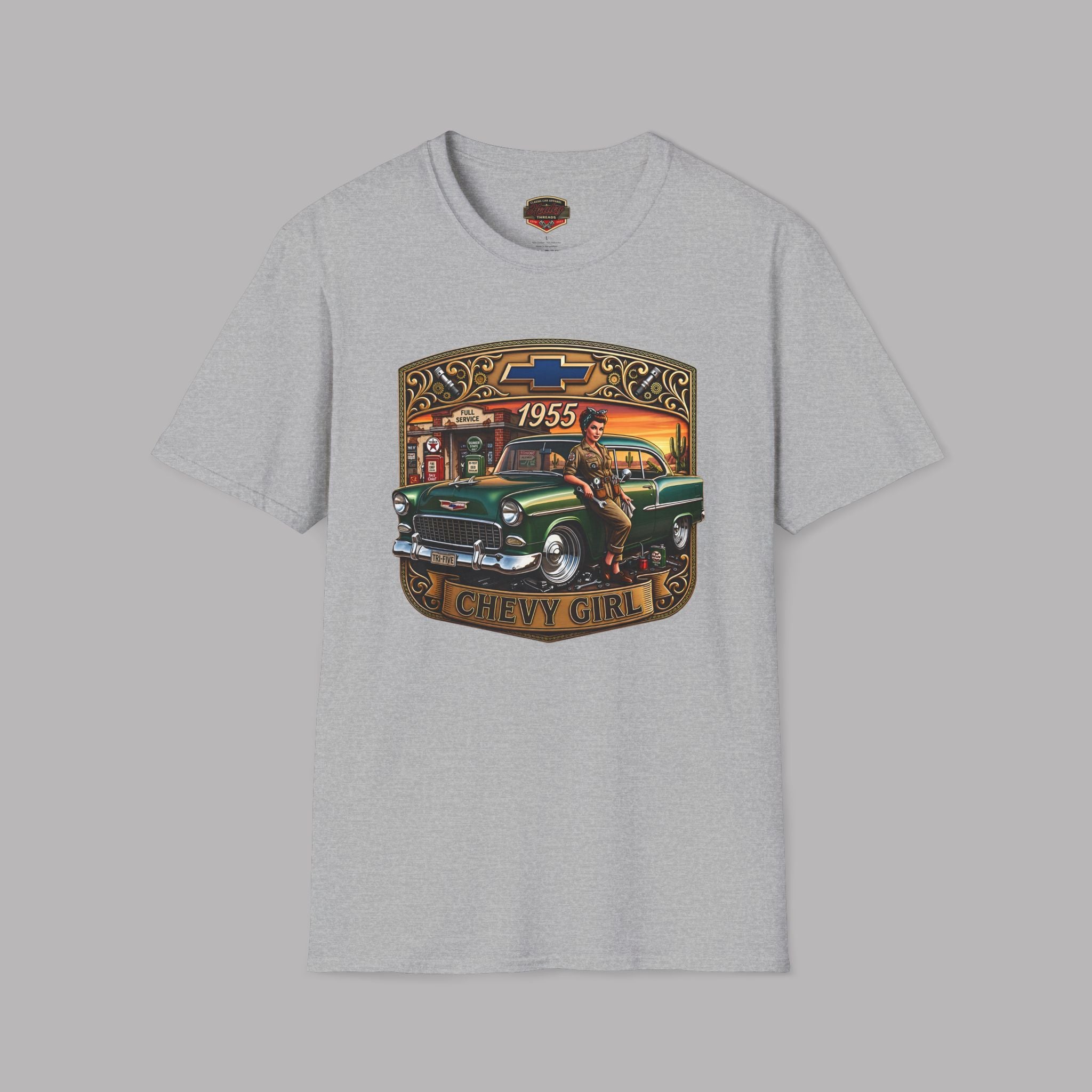 A sport gray short-sleeve t-shirt featuring a large graphic print on the front. The graphic depicts a vintage green 1955 Chevrolet truck with a woman in a cowboy hat, framed by a western-style border with the text '1955' and 'CHEVY GIRL'.