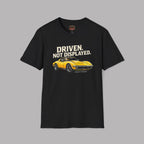 Black t-shirt with yellow muscle car graphic and text 'Driven. Not Displayed.' on a gray background