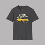 Dark heather t-shirt with a yellow muscle car graphic and text 'Driven. Not Displayed.' on a gray background