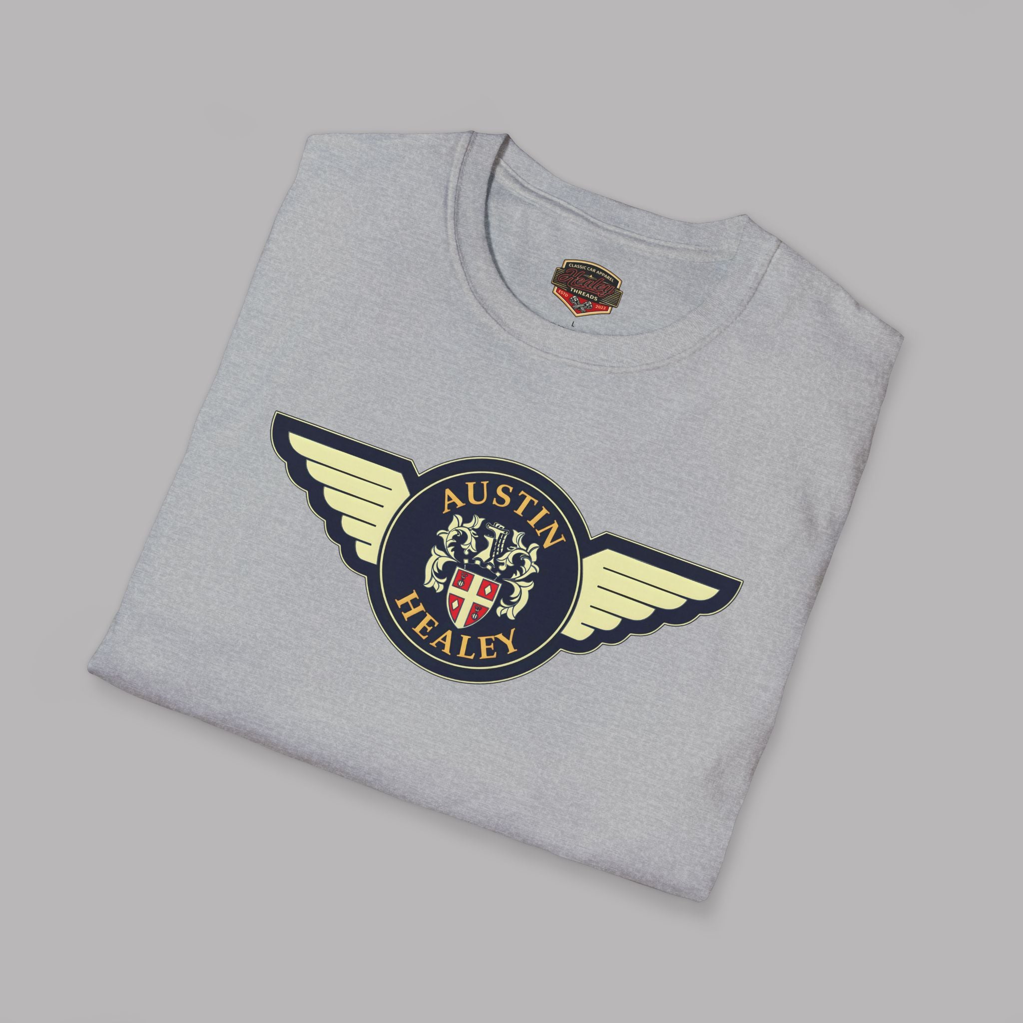 Folded gray t-shirt with Austin Healey logo on a gray background