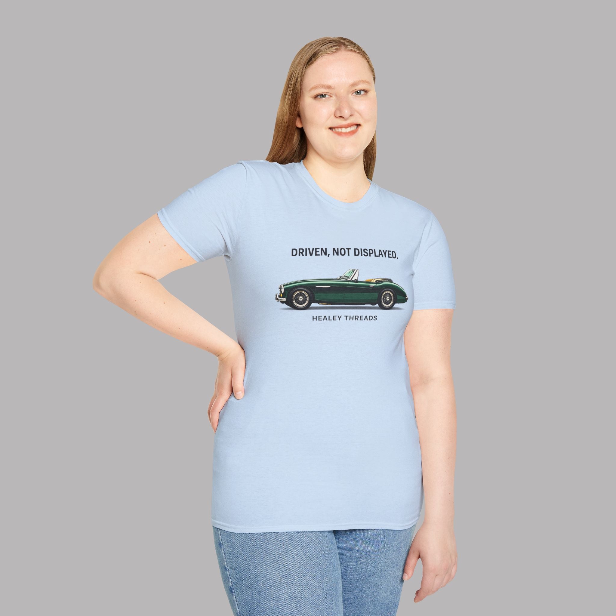 Woman wearing a light blue t-shirt with a classic car graphic and text on a gray background