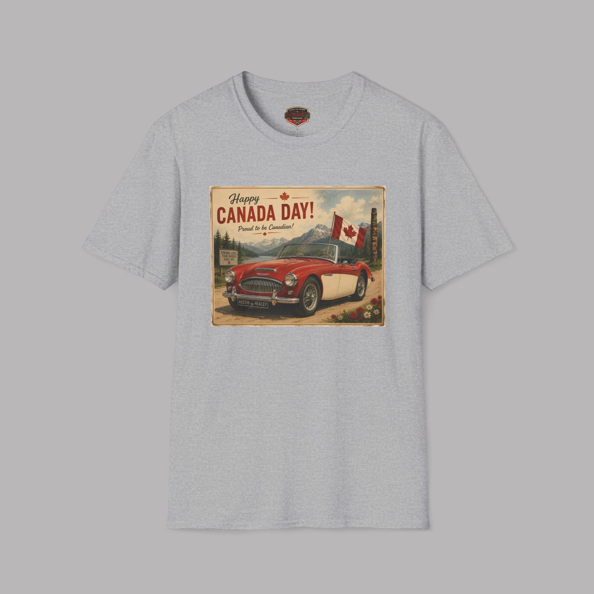 A sport gray crewneck t-shirt featuring a vintage-style 'Happy Canada Day!' graphic print on the chest, showing a red convertible car and a Canadian flag.