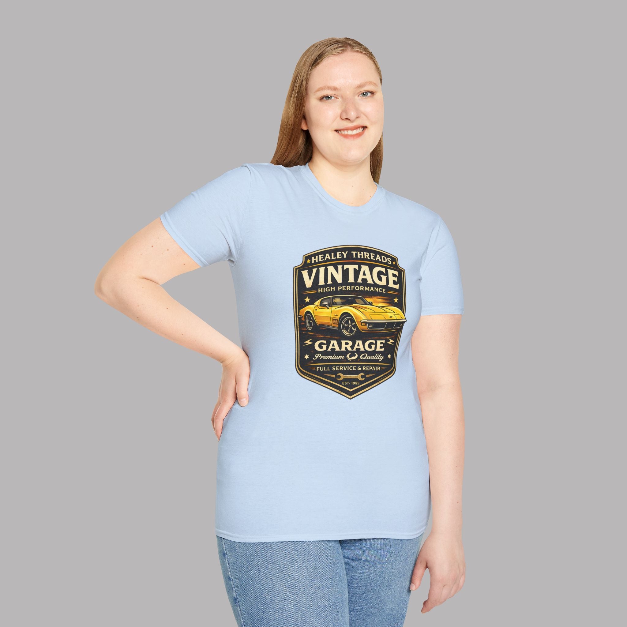 Woman wearing a light blue t-shirt with a vintage classic car graphic on a gray background