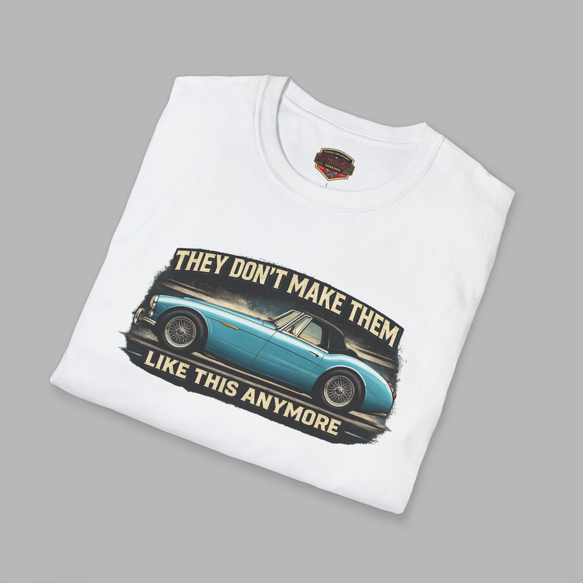 Folded white t-shirt with a graphic of a classic car and text on a gray background