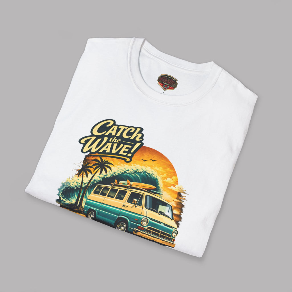 Folded white t-shirt with a graphic design of a van and 'Catch the Wave!' text on a gray background