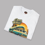 Folded white t-shirt with a graphic design of a van and 'Catch the Wave!' text on a gray background