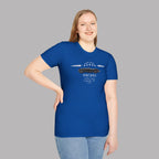 Woman wearing a royal blue t-shirt with a graphic car design on a gray background