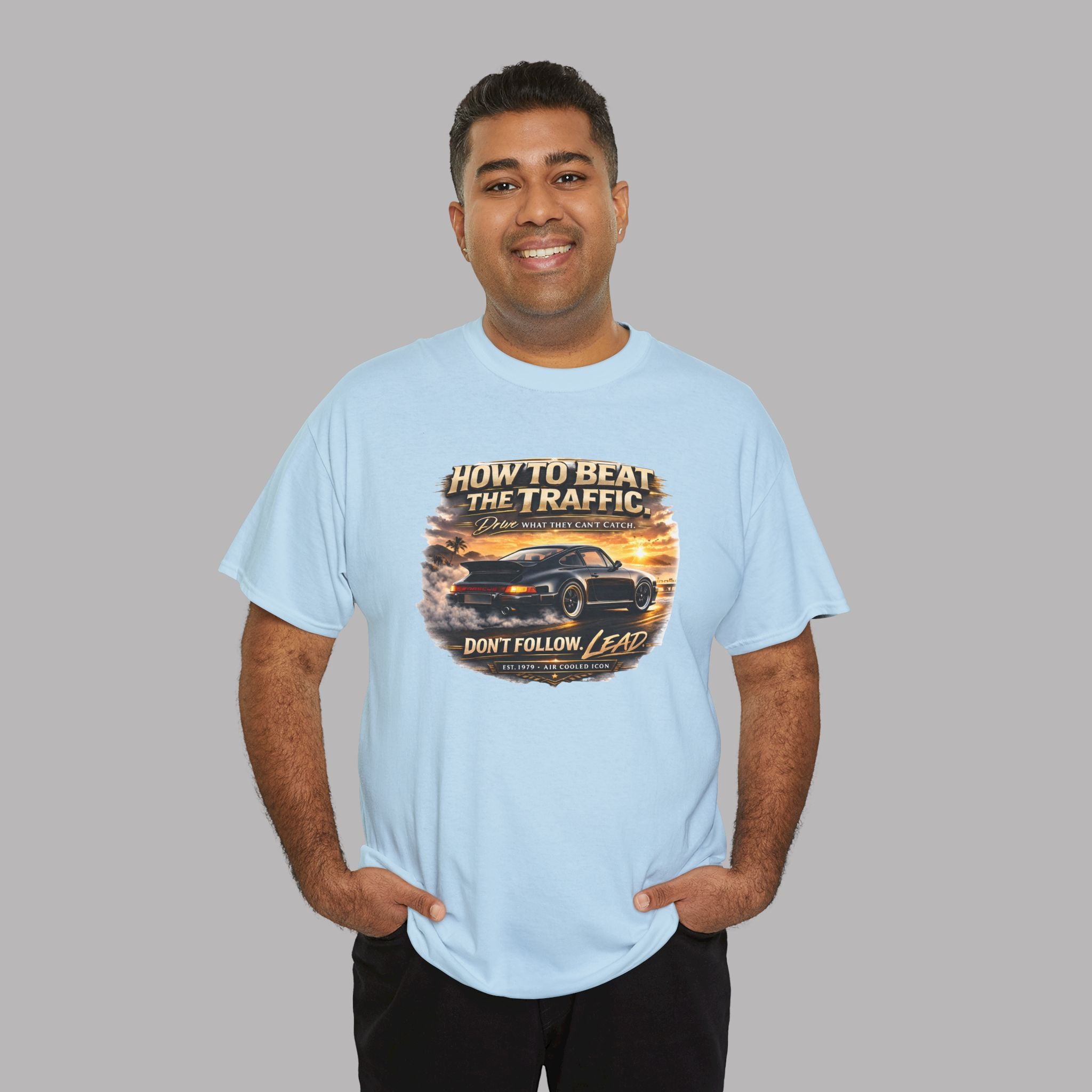 Man wearing a light blue t-shirt with a classic car graphic design and text on a gray background