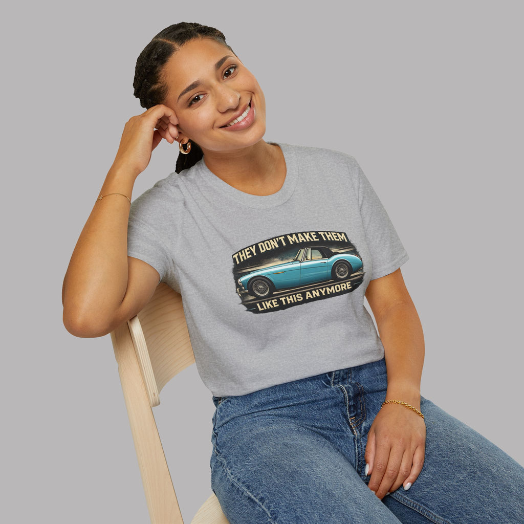 Woman wearing a sport gray t-shirt with a graphic design and text, sitting on a chair against a plain background.