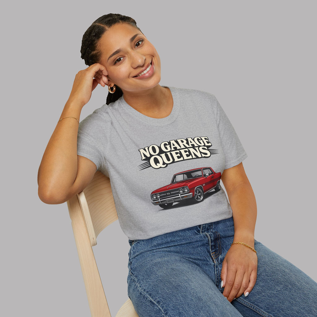 Woman wearing a sport gray t-shirt with 'No Garage Queens' graphic design sitting on a chair.