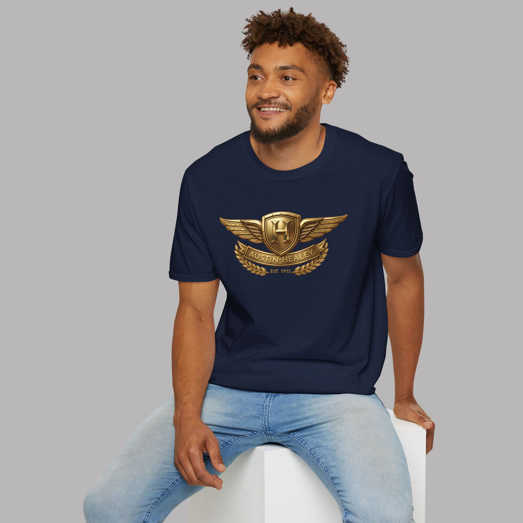 Man wearing a navy blue t-shirt with a gold Healey emblem on a gray background