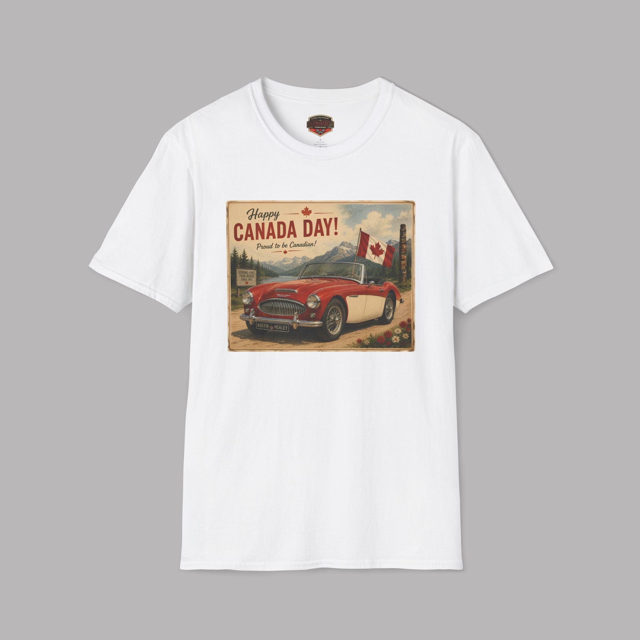 A white crewneck t-shirt featuring a vintage-style 'Happy Canada Day!' graphic print on the chest, showing a red convertible car and a Canadian flag.