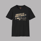 Black t-shirt with vintage car graphic and text 'Drive it. Don't park it.' on a gray background