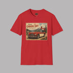 A red short-sleeve crewneck t-shirt featuring a vintage-style Canada Day graphic print on the chest, displayed against a solid gray background.