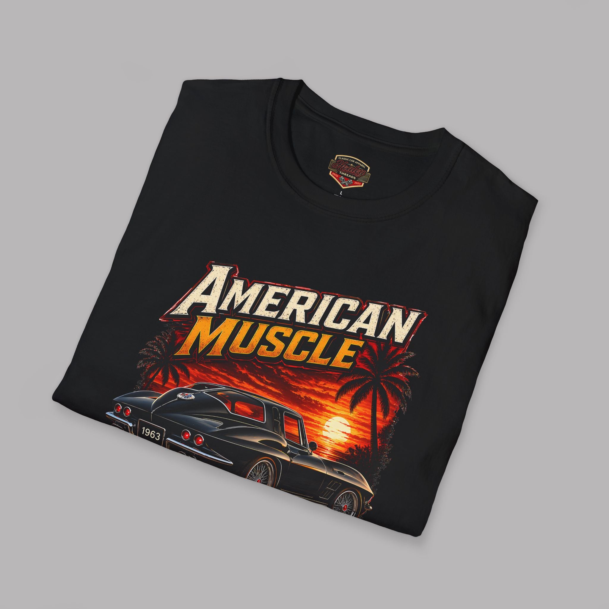 Folded black t-shirt with an 'American Muscle' car graphic design on a gray background