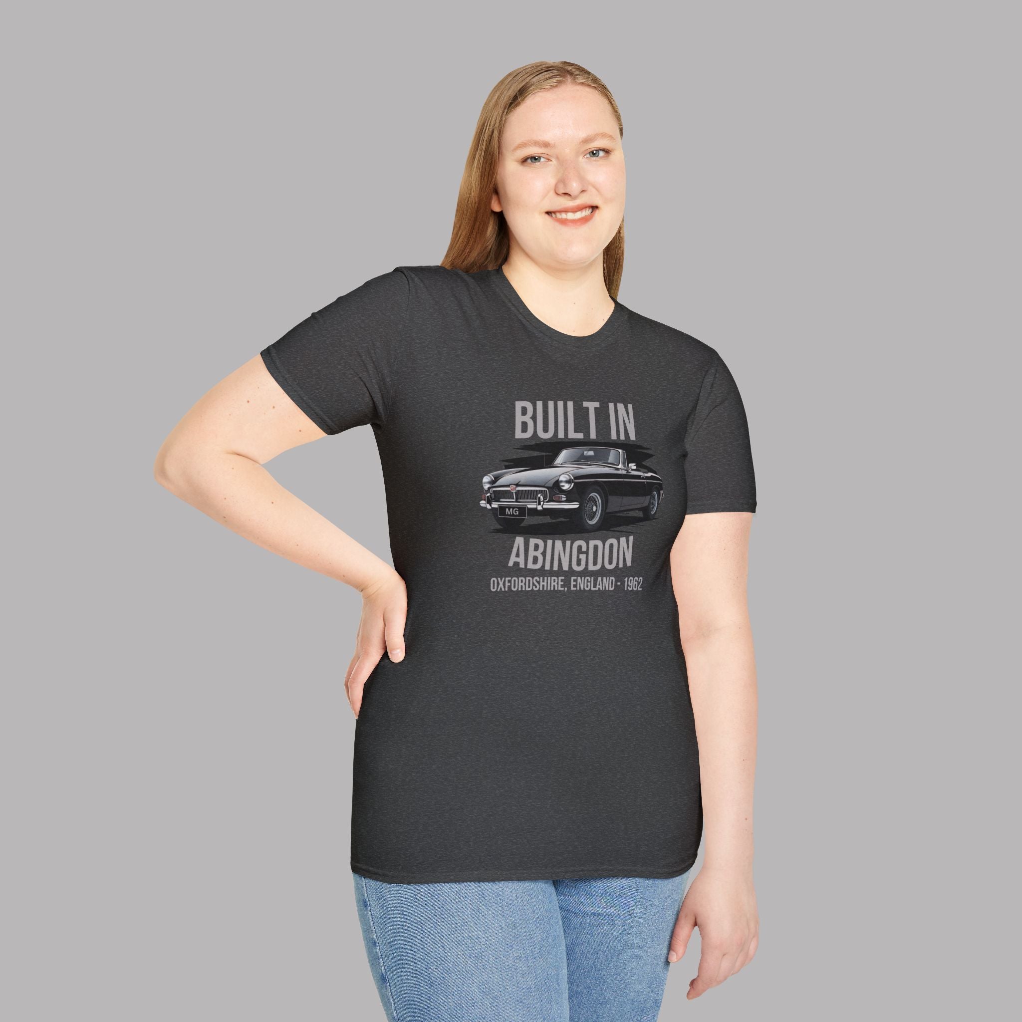 Woman wearing a black t-shirt with a classic car graphic and text on a gray background