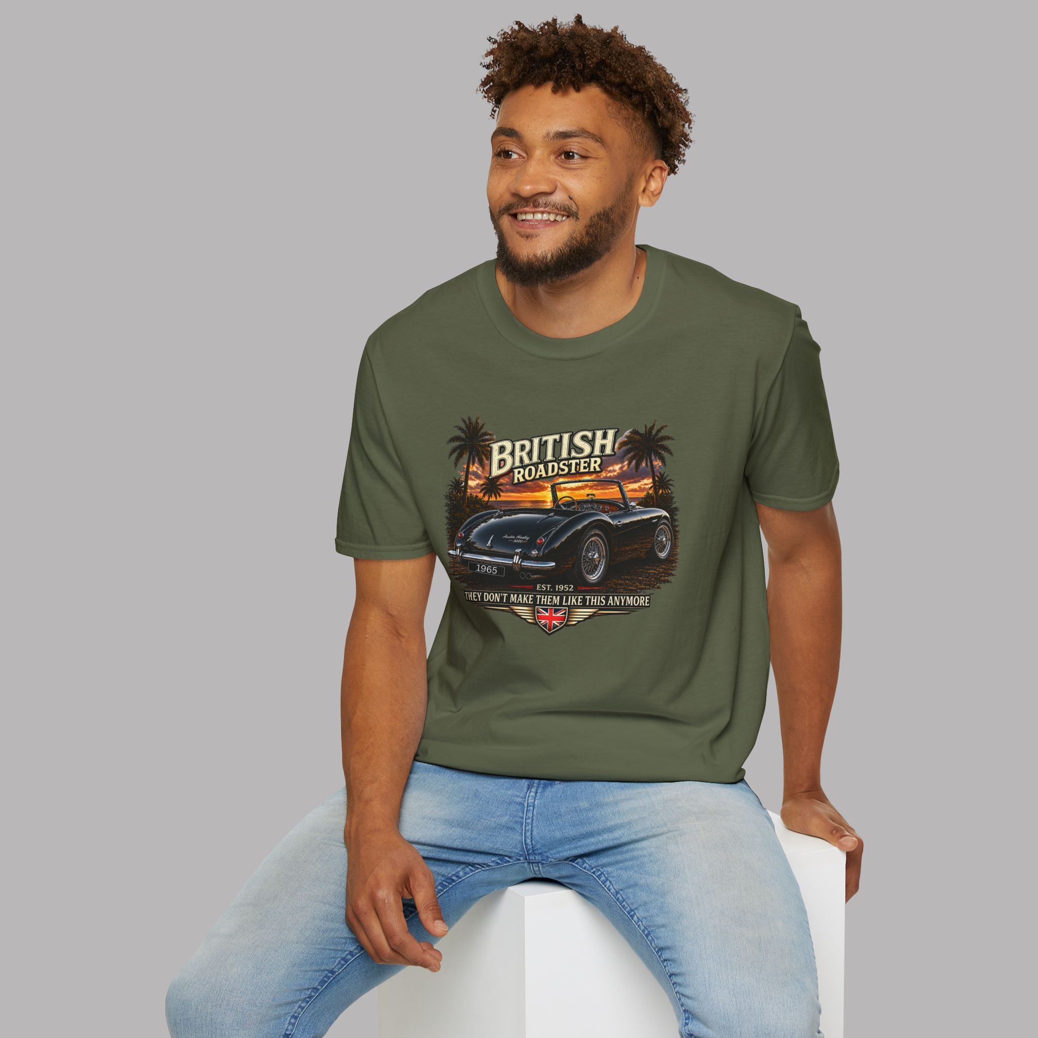 Man wearing a military green t-shirt with a car graphic and text on a gray background