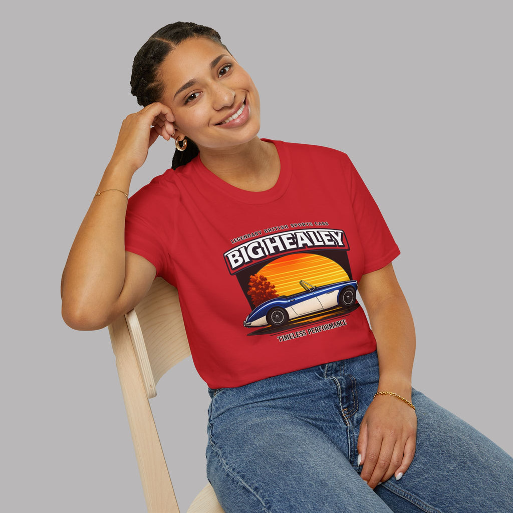 Woman wearing a Big Healey graphic red colored t-shirt featuring a blue and white Austin Healey roadster with retro sunset artwork and vintage British sports car on a gray background 