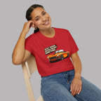 Woman wearing a red t-shirt with a graphic design of a car and text, sitting on a chair against a gray background.