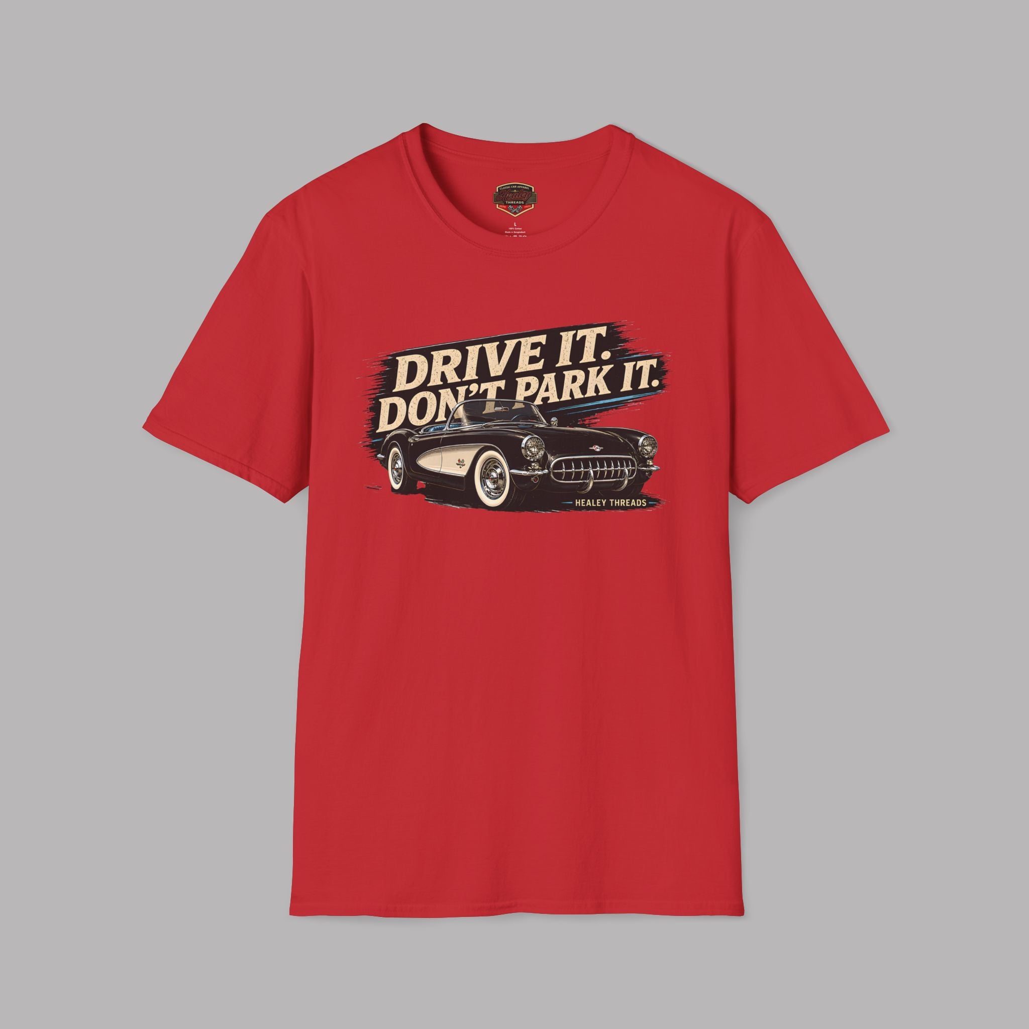 Red t-shirt with a graphic of a vintage car and text 'Drive It. Don't Park It.' on a gray background
