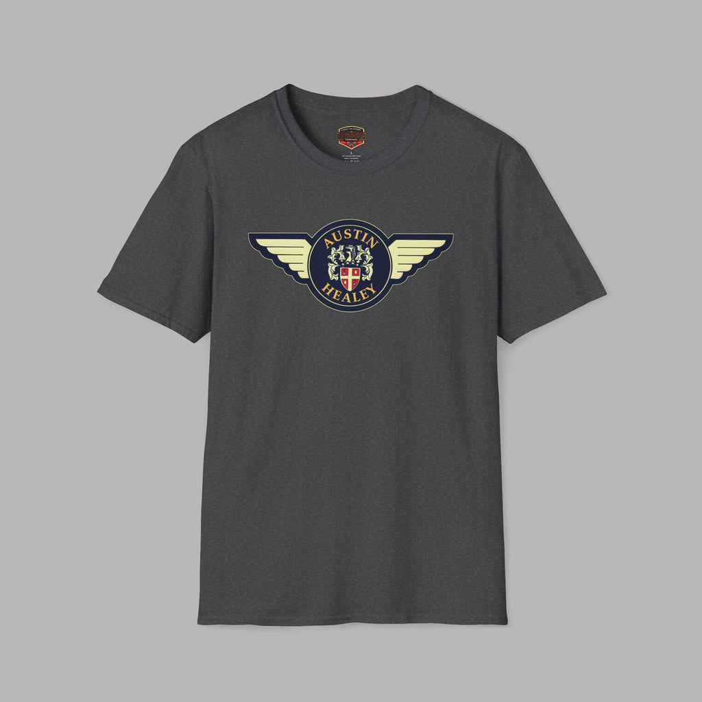 Austin Healey winged badge logo with navy and gold circular emblem, heraldic shield, and cream wings on a dark heather t-shirt flat on gray background