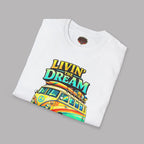 Folded white t-shirt with 'Livin' the Dream' graphic  design featuring a van and rainbow colors on a gray background.