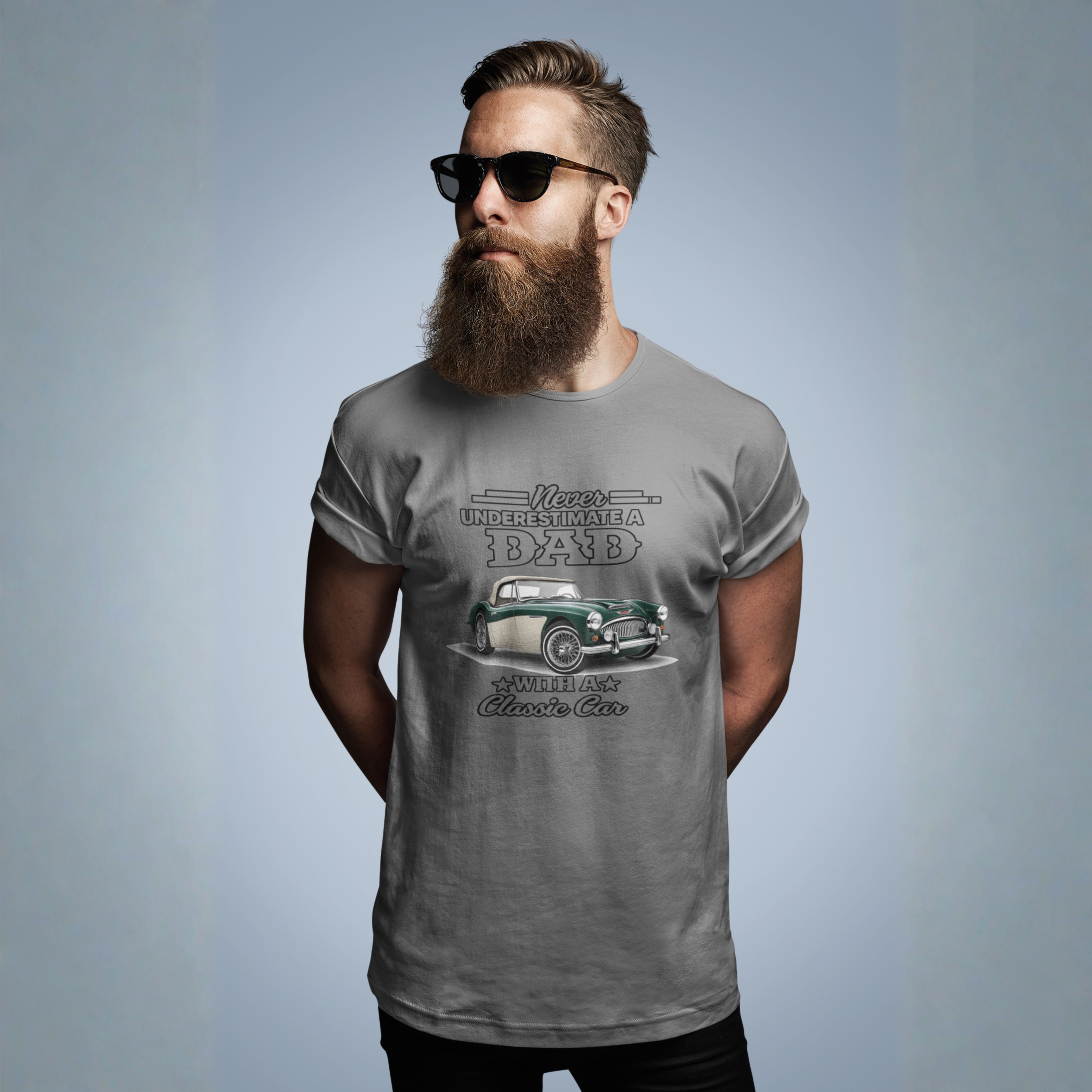 Man wearing a gray t-shirt with a vintage Healey car graphic and text on a plain background