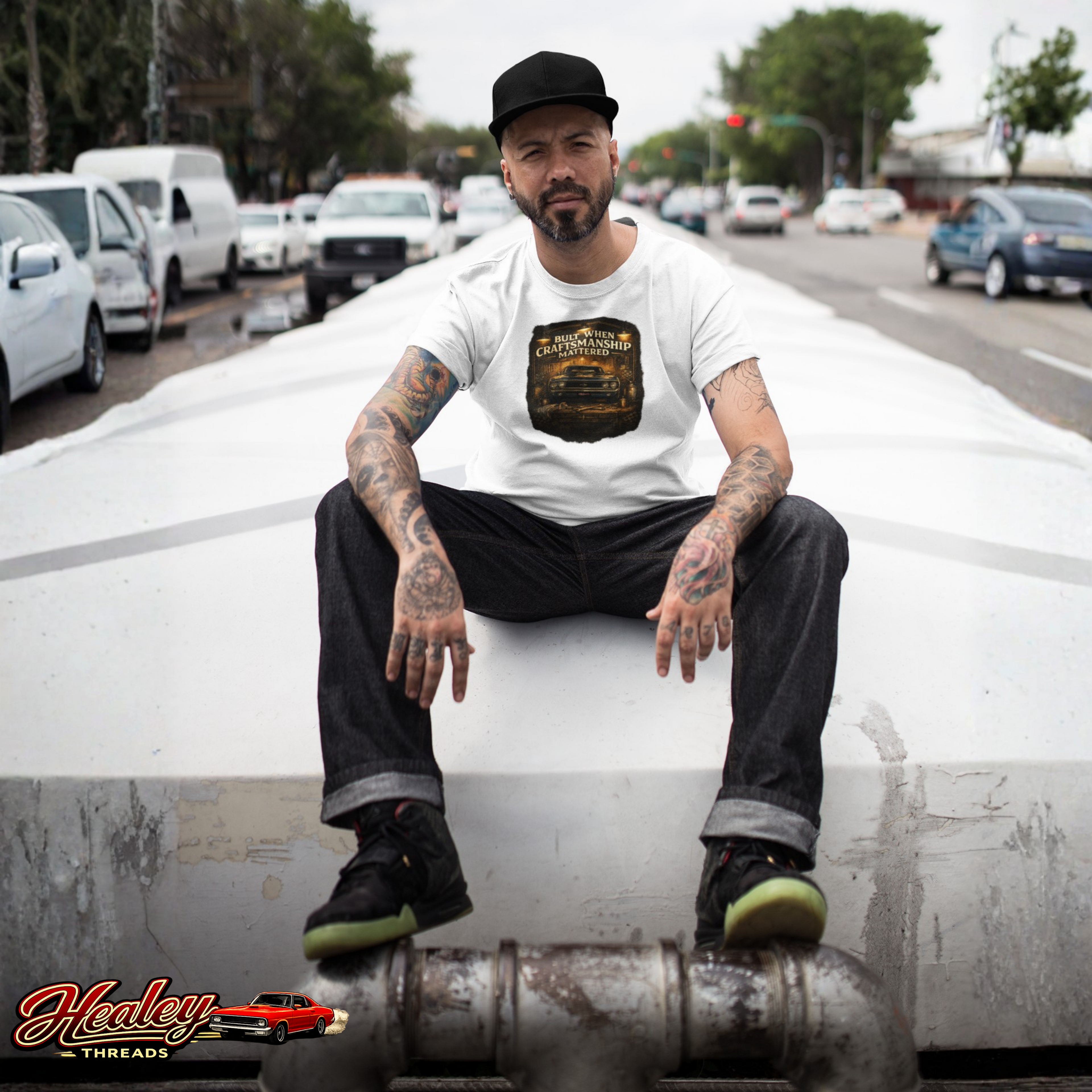 Man sitting on a vehicle's exhaust pipe with a city street background