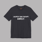 Dark gray t-shirt with white text "Cheaper than therapy. Barely." on a gray background