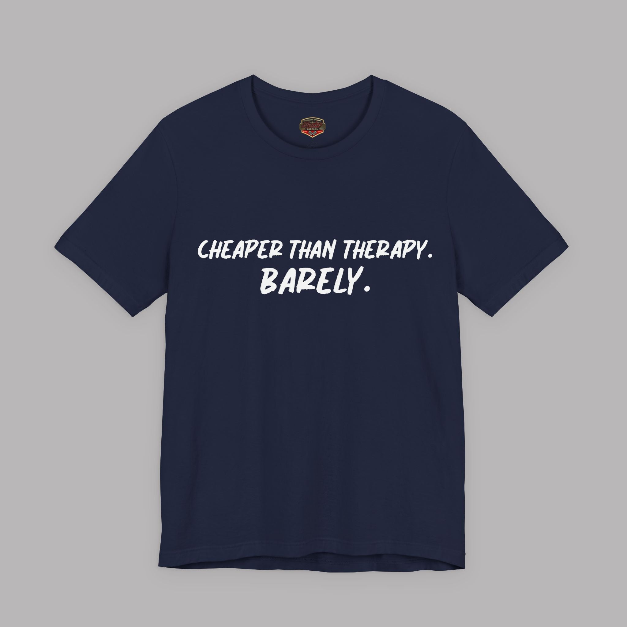Navy blue  t-shirt with white text "Cheaper than therapy. Barely." on a gray background