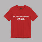 A red short-sleeve crewneck t-shirt with the text 'CHEAPER THAN THERAPY. BARELY.