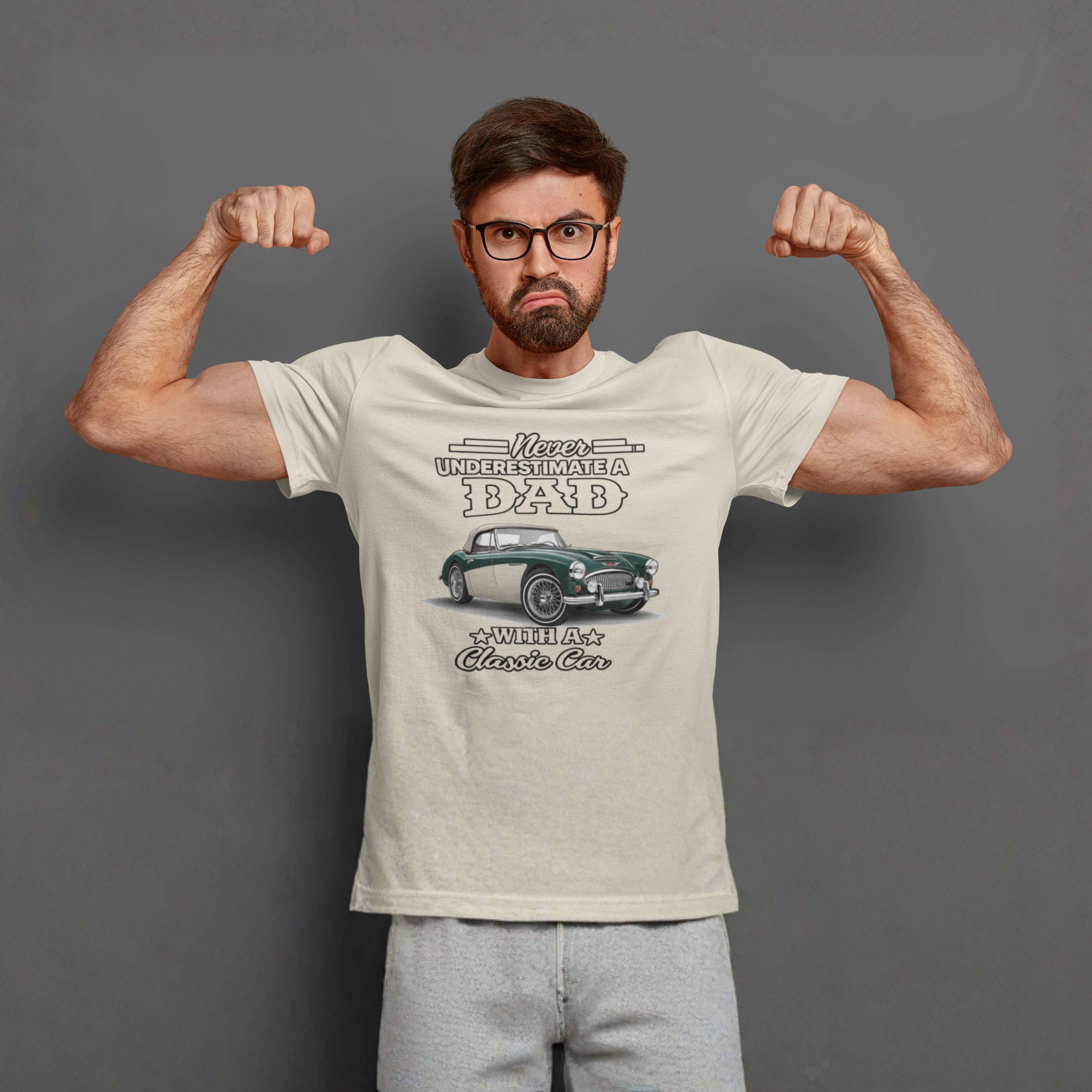 Man flexing muscles wearing a t-shirt with a graphic Healey design on a gray background