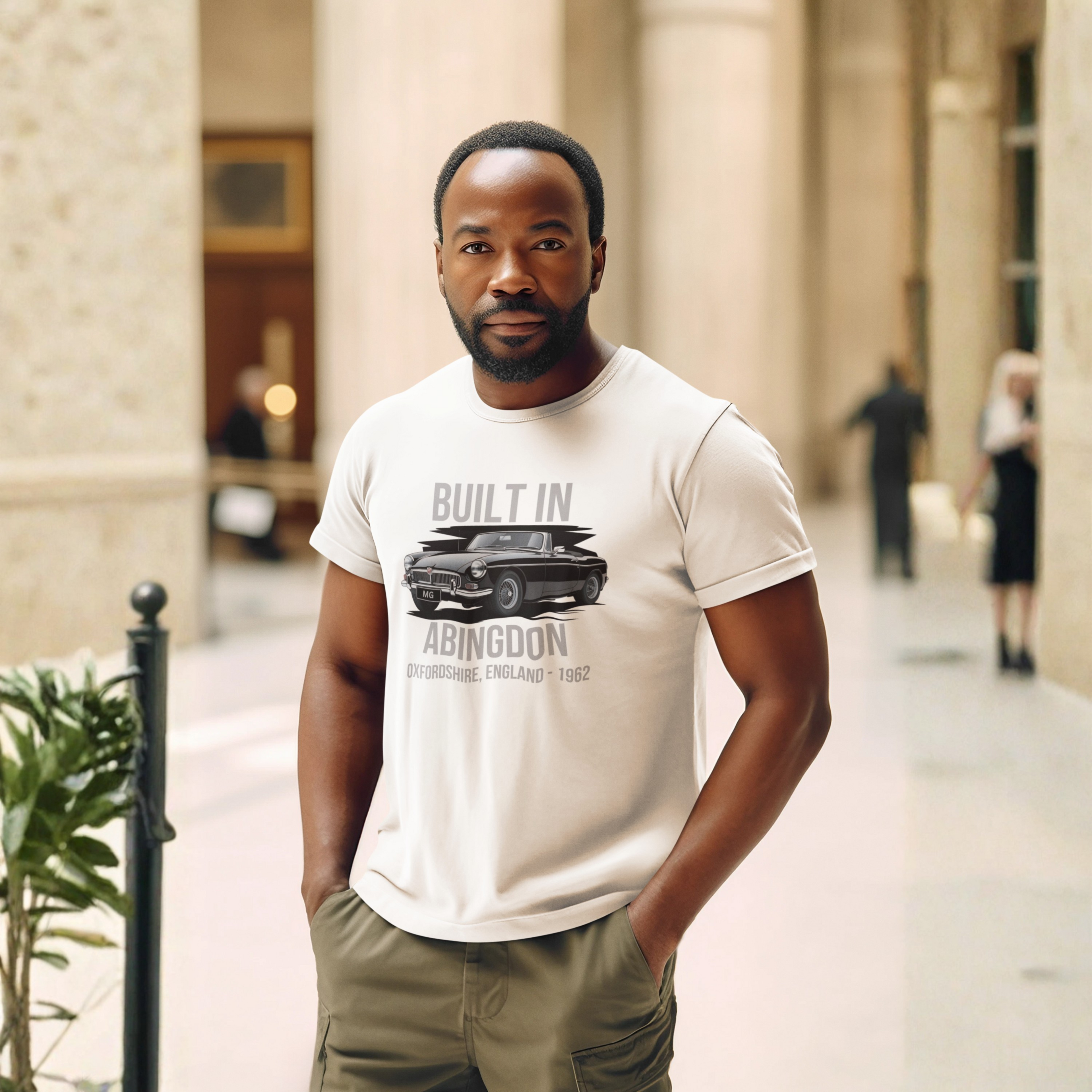 Man wearing a natural t-shirt with graphic MGB car design in an indoor setting