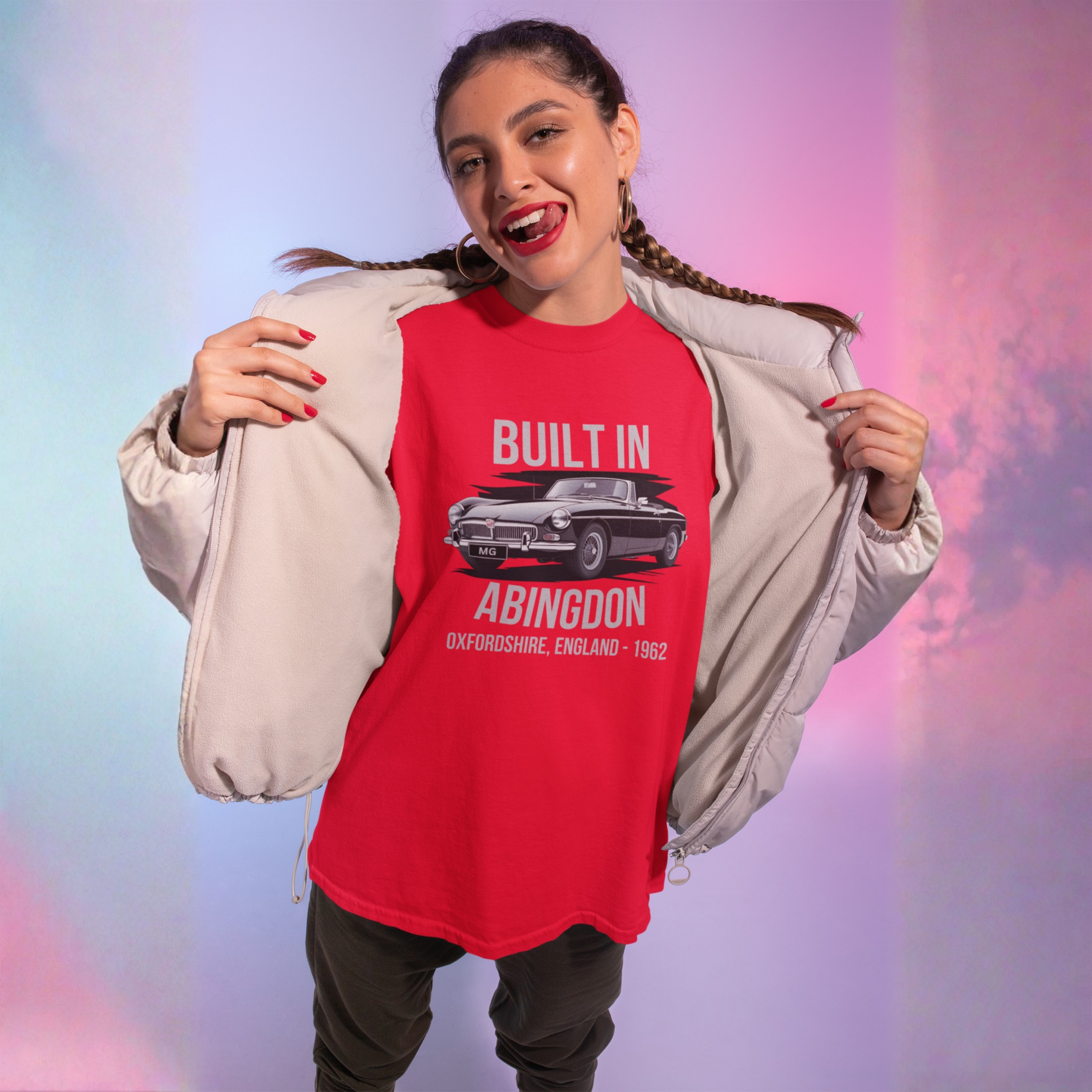 Woman wearing a red 'Built in Abingdon' t-shirt with a MGB car graphic against a colorful gradient background