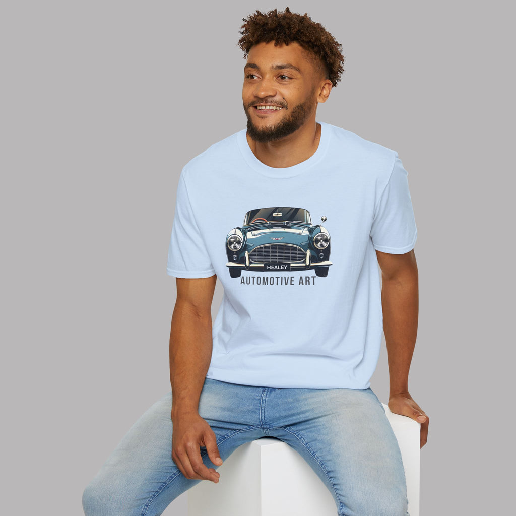 Man wearing a light blue t-shirt with a Healey car graphic and text, sitting on a white stool against a gray background.