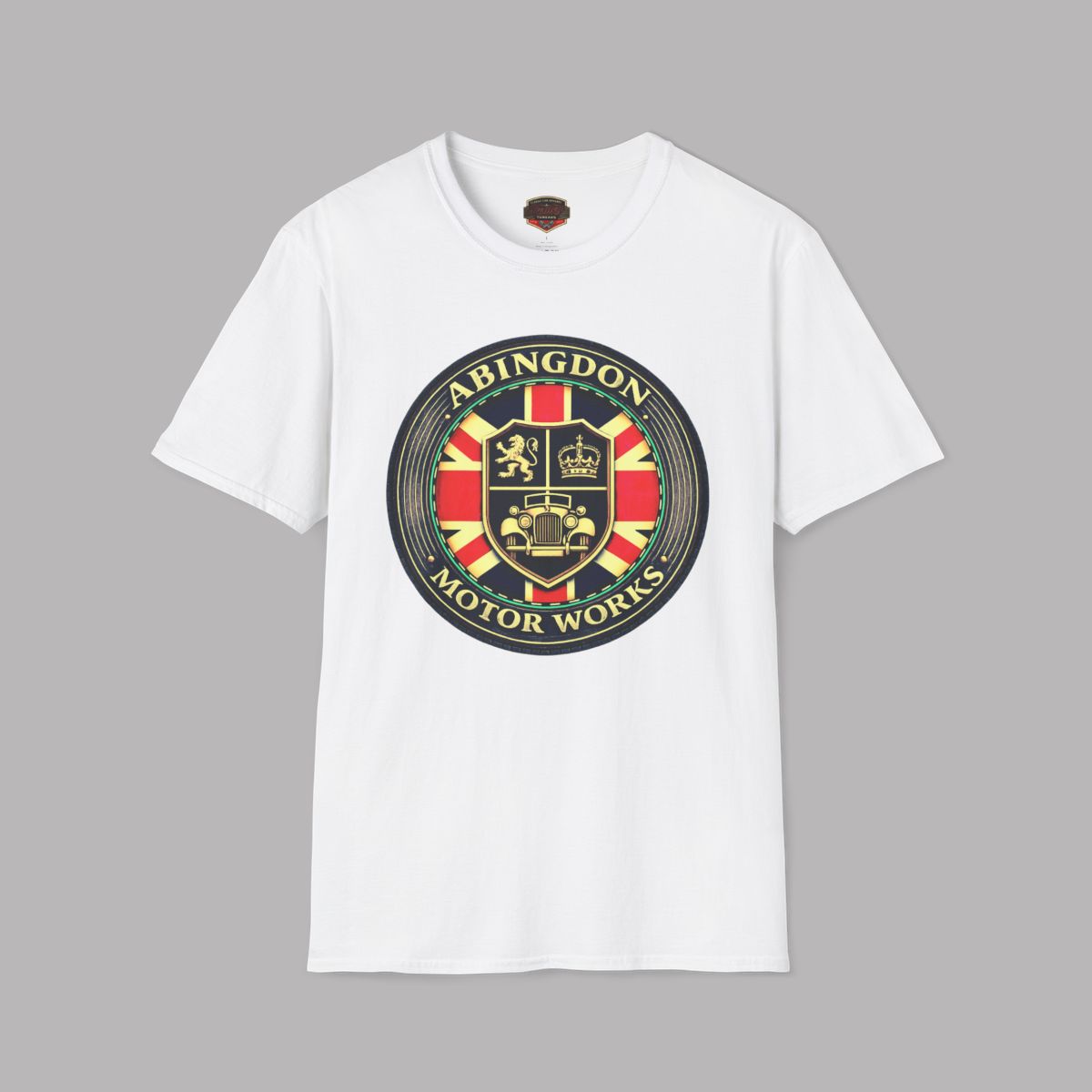 A white short-sleeve crewneck t-shirt featuring a circular 'Abingdon Motor Works' crest graphic printed on the chest, displayed against a solid gray background.