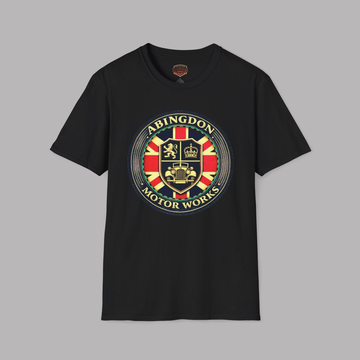 Black t-shirt featuring a circular 'Abingdon Motor Works' crest graphic on the chest, styled in a flat-lay arrangement on a gray background