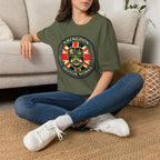 Person wearing a military green t-shirt with a circular 'Abingdon Motor Works' crest printed on the chest sitting on the floor.