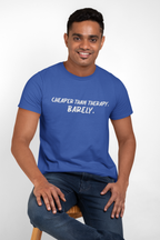 Man wearing a blue t-shirt with t-shirt with white text "Cheaper than therapy. Barely."  text, sitting on a stool against a white background